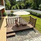 Raised backyard deck with safety railing, step, rocking chair, and patio umbrella beside a modern home.